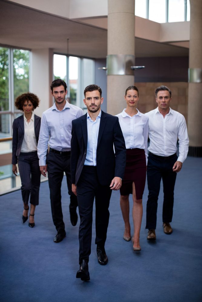 Portrait of business executives walking in a conference center lobby